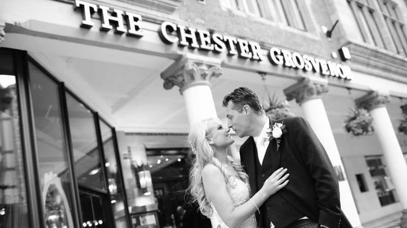 The Just Married Bride And Groom kiss outside The Chester Grosvenor
