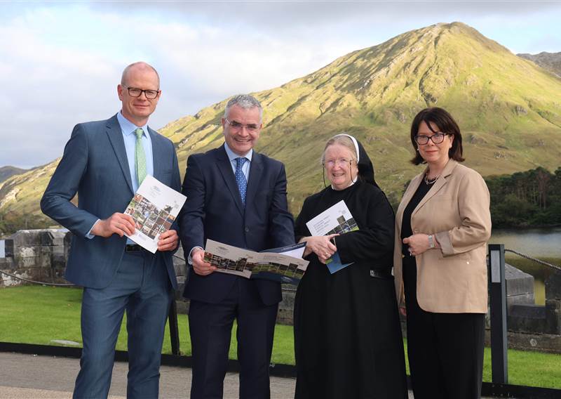 four people pictured with a report with a mountain in background