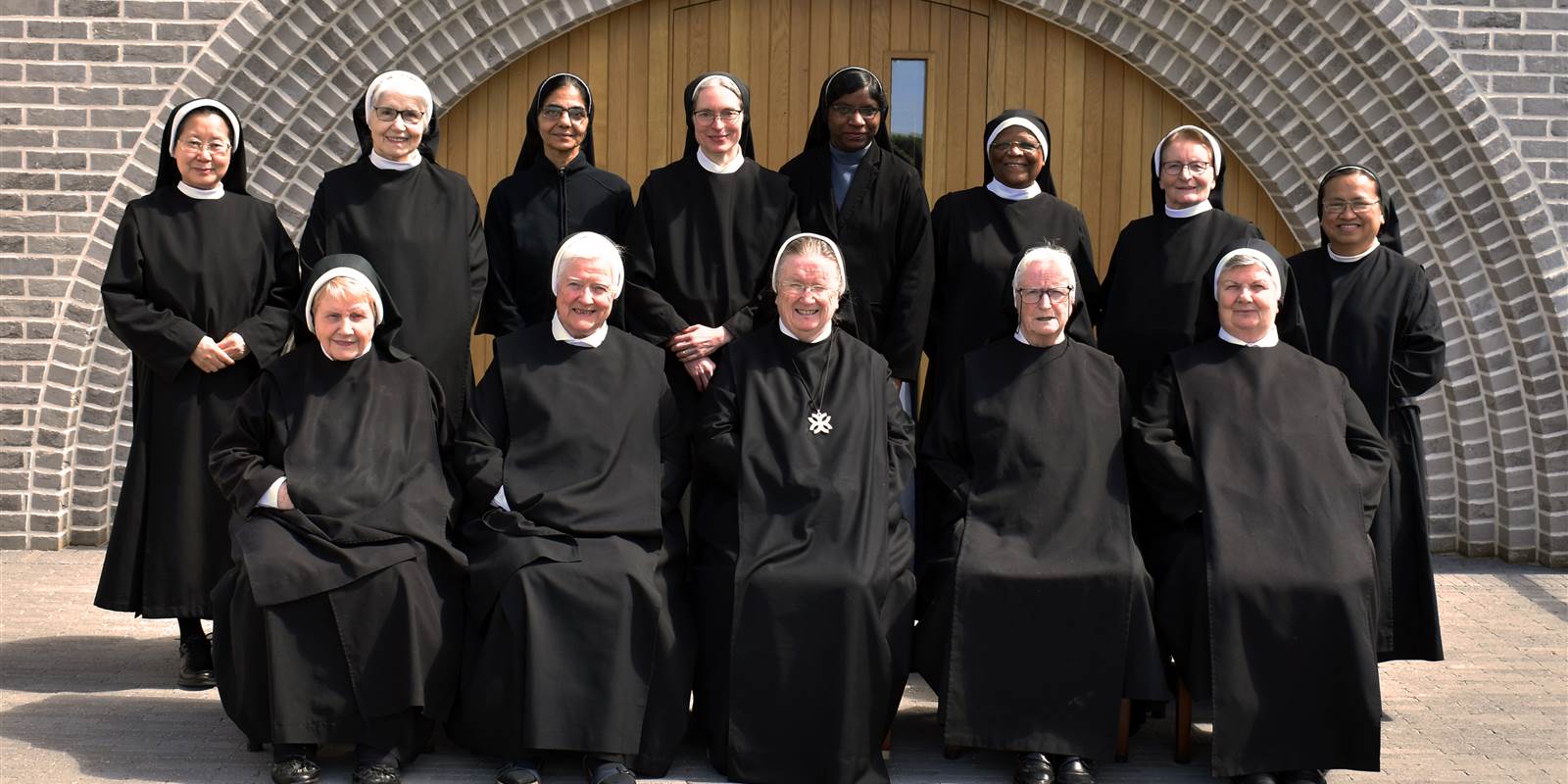 convent of nuns in front of a large circular door