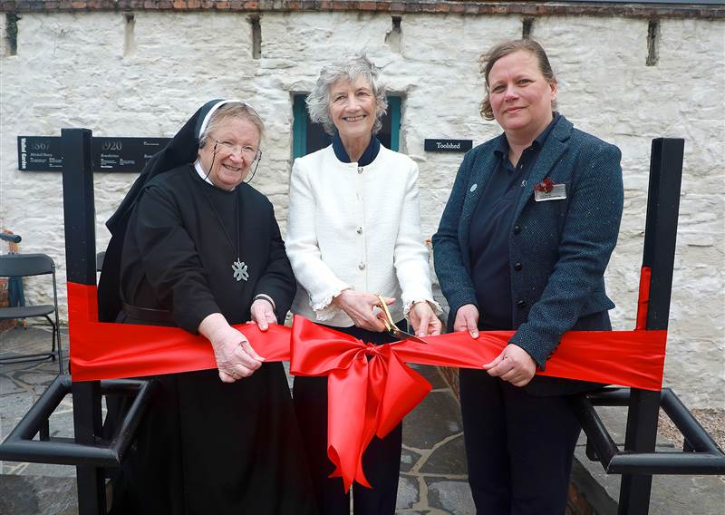 President of Ireland, Catherine Connolly cutting a red ribbon with a nun and a gardener