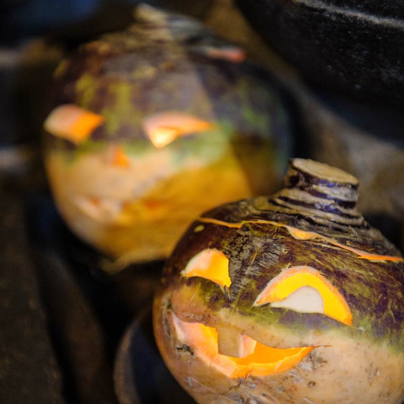 two halloween carved turnips lit up