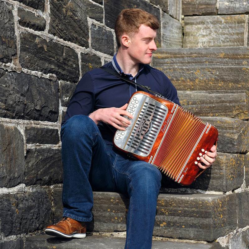 man playing the accordion on stone steps
