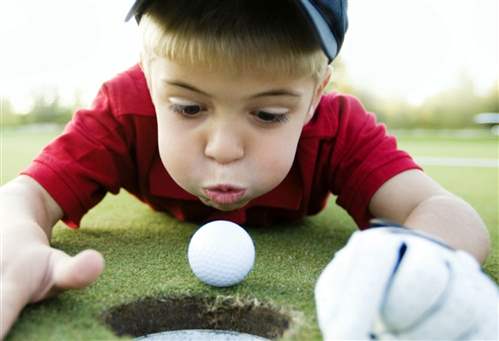 Child playing with golf ball