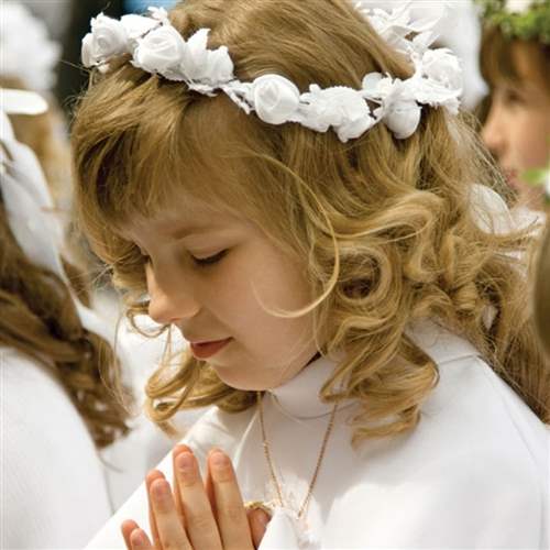 First communion for a blonde girl with curly hair 
